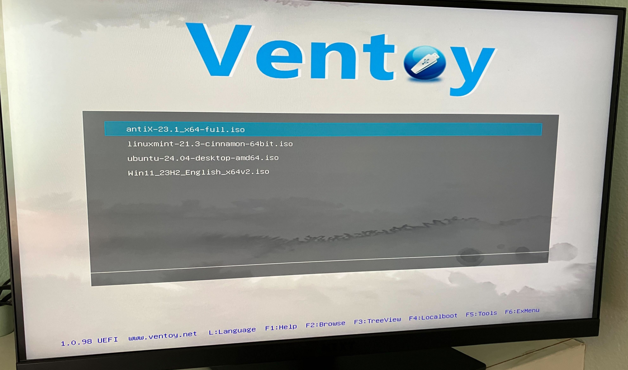 Ужасная фотография монитора моего компьютера с мобильного телефона. Я загружаю Ventoy и могу выбирать между четырьмя файлами ISO, которые я добавил на скриншоте выше 